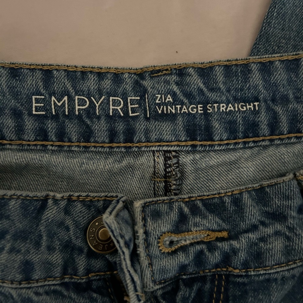 Jeans worn heavily, bottoms are a little ragged